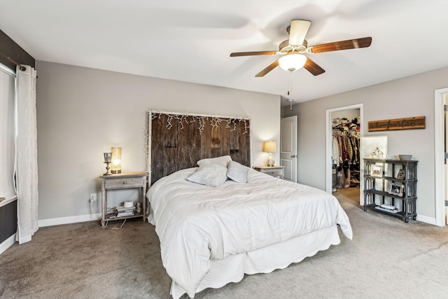 carpeted bedroom featuring ceiling fan, a walk in closet, and a closet