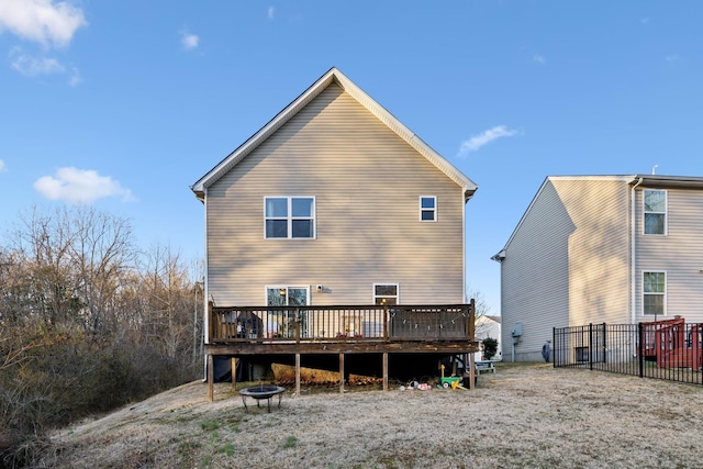 back of house featuring an outdoor fire pit and a deck