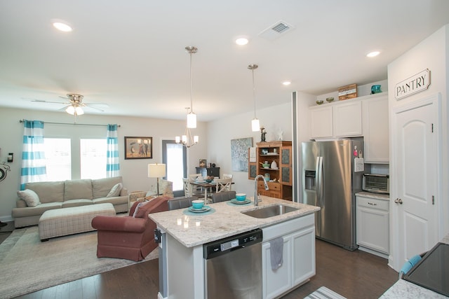 kitchen featuring pendant lighting, sink, appliances with stainless steel finishes, white cabinetry, and light stone counters