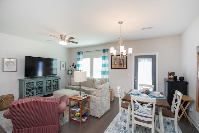 living room with dark hardwood / wood-style flooring and ceiling fan with notable chandelier