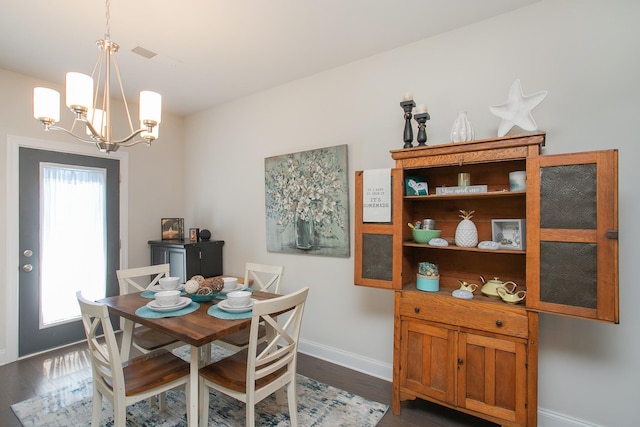 dining space featuring a chandelier, dark hardwood / wood-style floors, and a healthy amount of sunlight