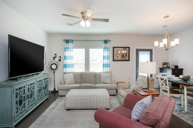 living room featuring ceiling fan with notable chandelier and dark hardwood / wood-style flooring