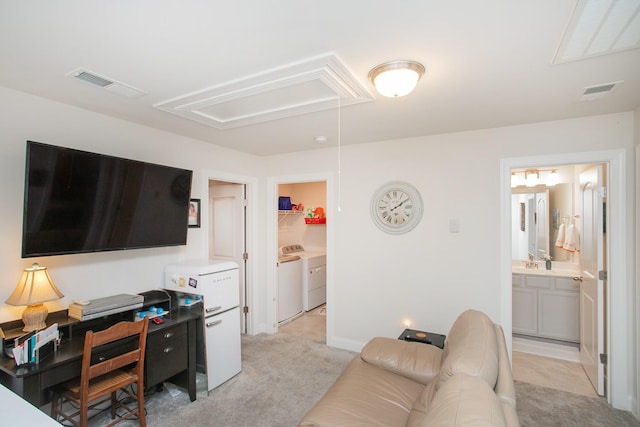 carpeted living room with separate washer and dryer and sink