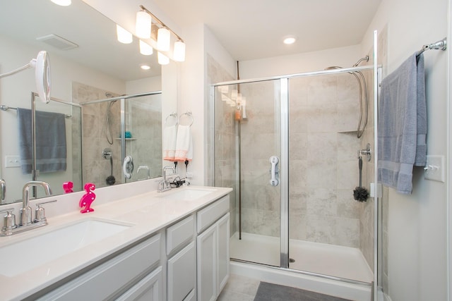 bathroom with vanity, a shower with shower door, and tile patterned flooring