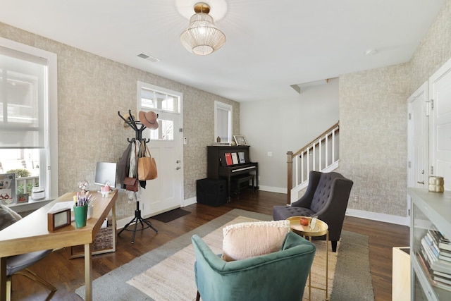 sitting room featuring dark wood-type flooring and a healthy amount of sunlight