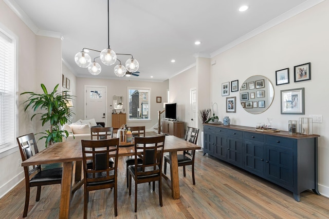 dining area featuring light wood-type flooring, baseboards, crown molding, and recessed lighting