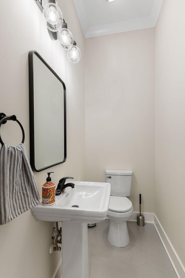 bathroom with crown molding, tile patterned flooring, toilet, and baseboards