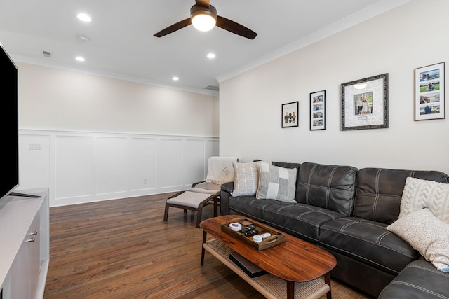 living area with dark wood-style floors, recessed lighting, crown molding, and a decorative wall