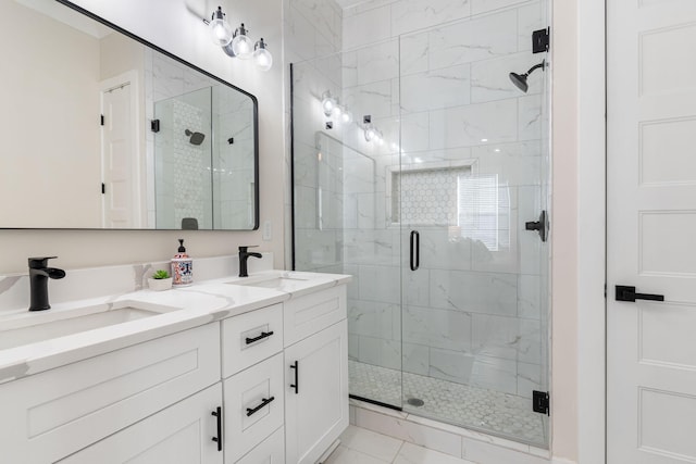 bathroom with a stall shower, a sink, and double vanity