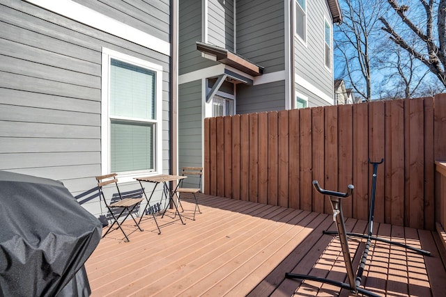 wooden deck with a grill and fence