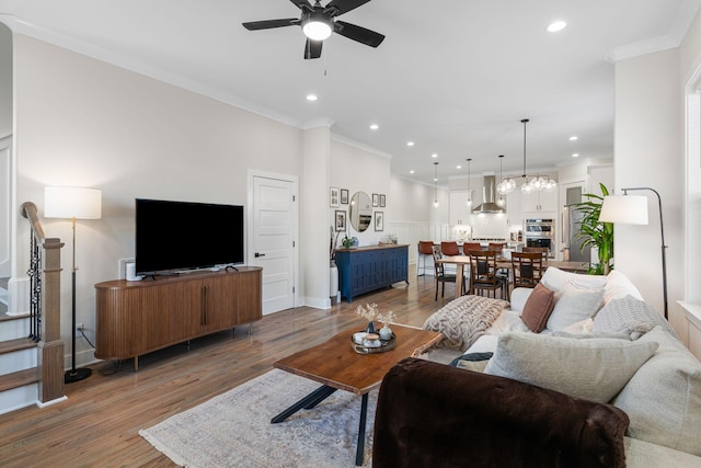 living room with hardwood / wood-style flooring, crown molding, and ceiling fan