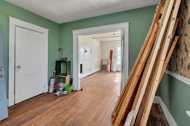 corridor featuring hardwood / wood-style floors and a textured ceiling