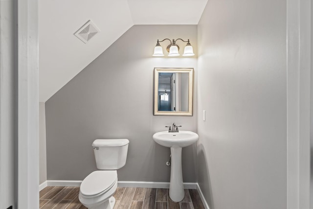 bathroom with vaulted ceiling and toilet