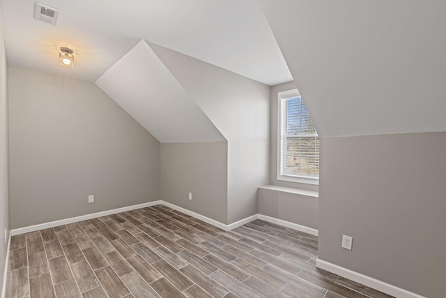 bonus room with wood-type flooring and vaulted ceiling