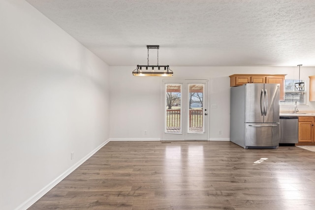 unfurnished dining area featuring dark hardwood / wood-style floors, sink, and a textured ceiling