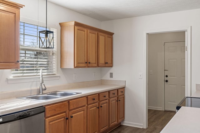 kitchen featuring pendant lighting, sink, dark wood-type flooring, dishwasher, and a textured ceiling