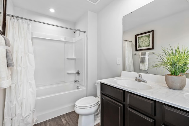 full bathroom featuring hardwood / wood-style flooring, vanity, shower / tub combo, and toilet