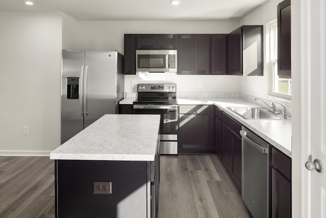 kitchen with a kitchen island, appliances with stainless steel finishes, sink, and hardwood / wood-style floors