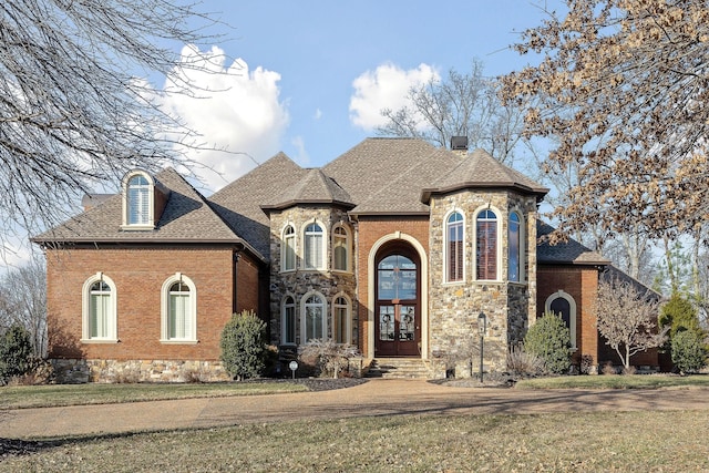 french country style house with a front lawn and french doors