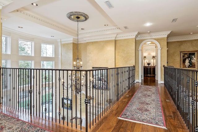 corridor with an inviting chandelier, dark hardwood / wood-style flooring, and crown molding