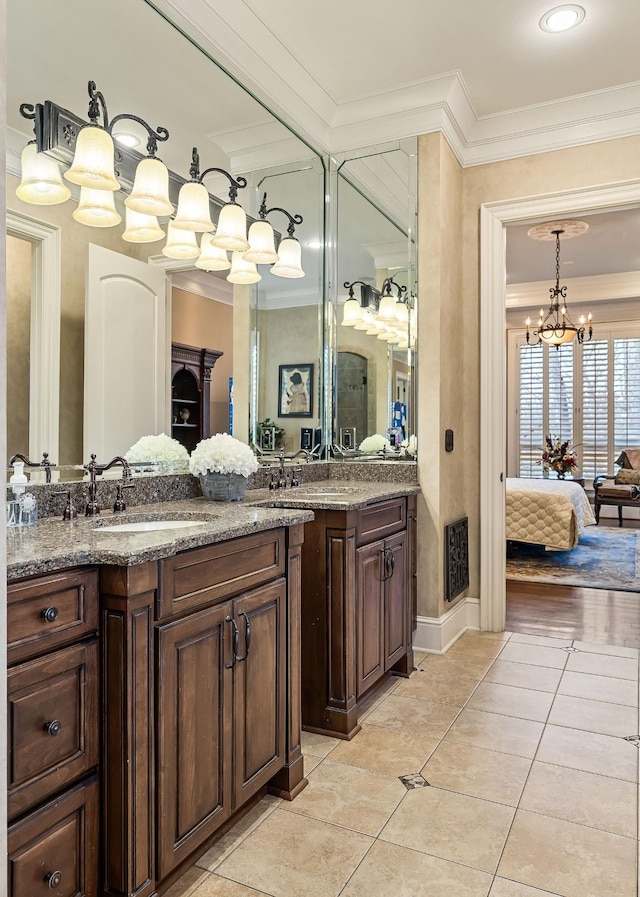 bathroom featuring tile patterned flooring, vanity, an inviting chandelier, and crown molding