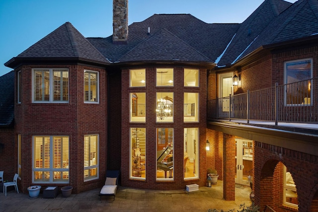 back house at dusk with a patio