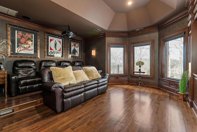 home theater room with hardwood / wood-style floors, crown molding, and a raised ceiling