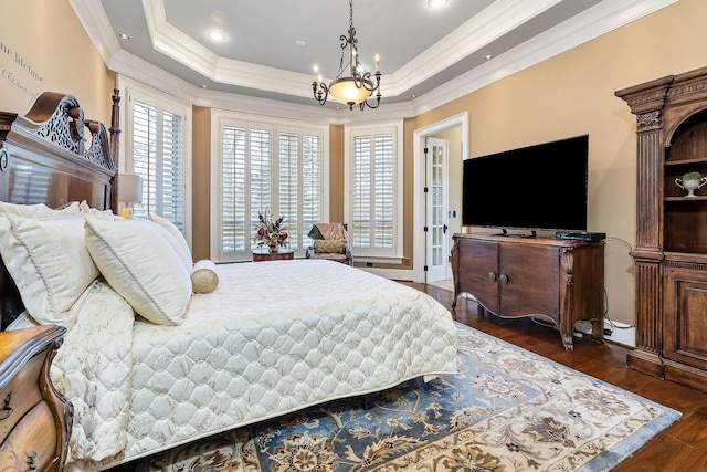 bedroom with dark hardwood / wood-style flooring, crown molding, a raised ceiling, and a chandelier