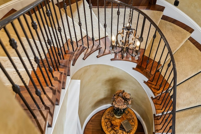 staircase with a notable chandelier