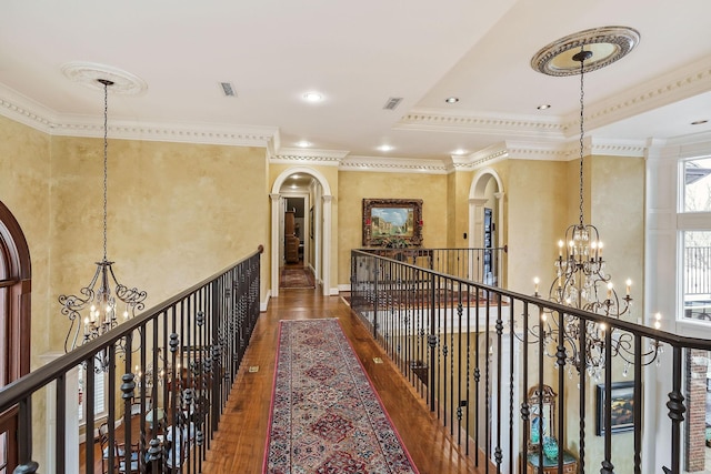 hall with crown molding, dark hardwood / wood-style floors, and an inviting chandelier