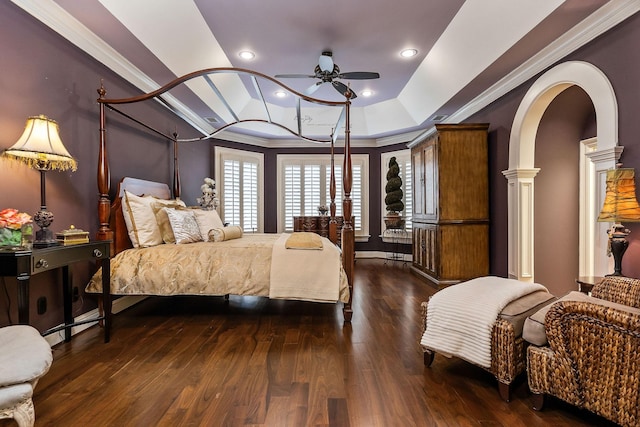 bedroom featuring dark hardwood / wood-style floors, ornamental molding, a raised ceiling, and ceiling fan