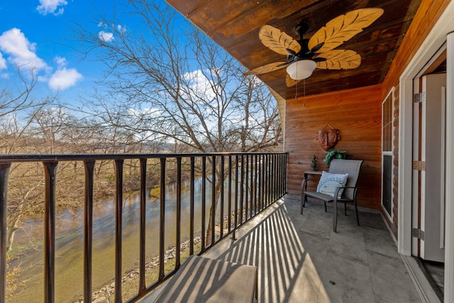 balcony featuring a water view and ceiling fan