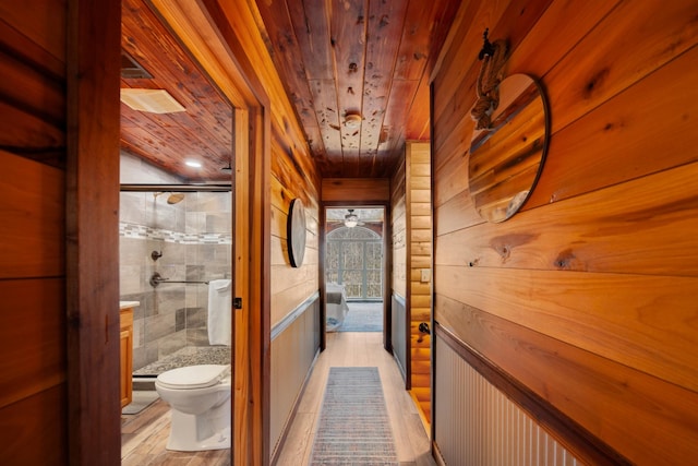 corridor featuring light hardwood / wood-style floors and wooden ceiling