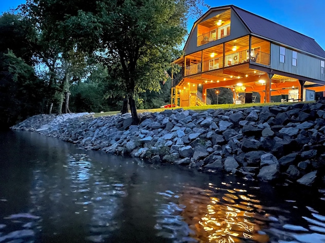 back of house featuring a balcony and a water view