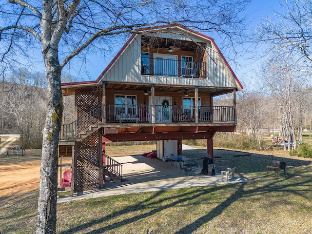 view of front of house featuring a front yard, a patio area, a balcony, and ceiling fan