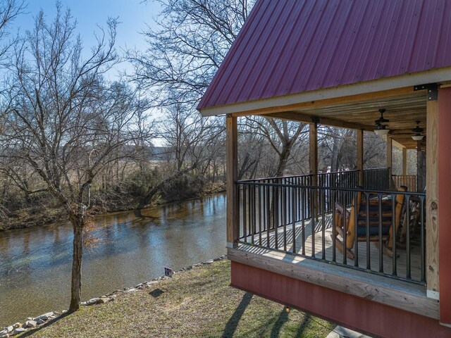 wooden deck featuring a water view and ceiling fan