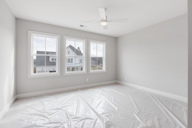 unfurnished room featuring plenty of natural light and ceiling fan