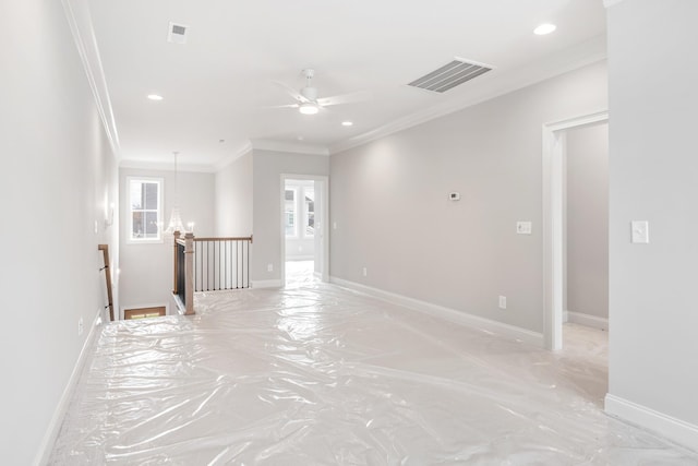 unfurnished room with ceiling fan and ornamental molding