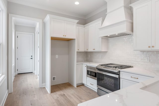 kitchen featuring light stone counters, stainless steel appliances, custom exhaust hood, and white cabinets