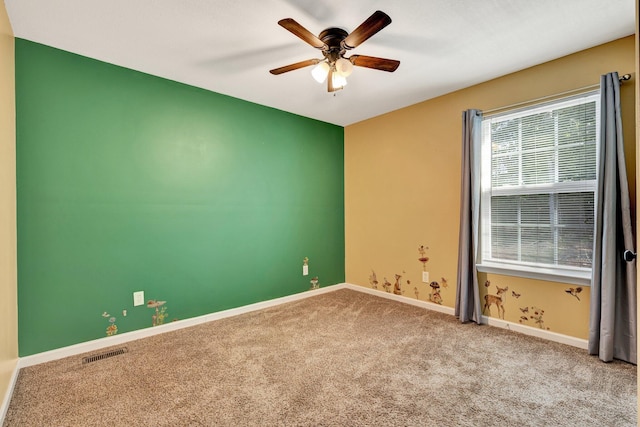 carpeted empty room featuring visible vents, ceiling fan, and baseboards