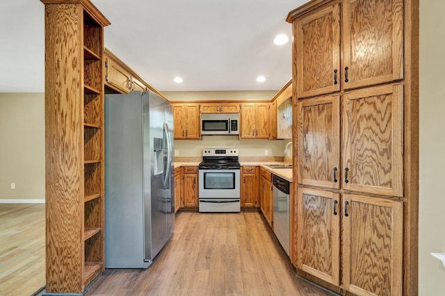 kitchen with stainless steel appliances, light countertops, light wood-type flooring, open shelves, and brown cabinetry