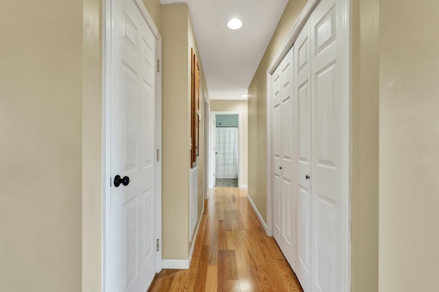 hall with light wood finished floors, baseboards, and recessed lighting