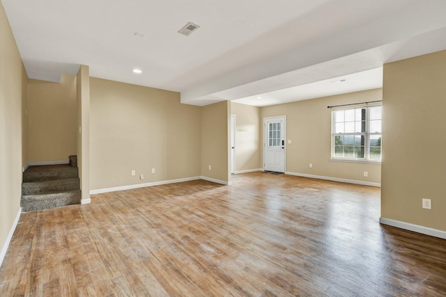 unfurnished room with recessed lighting, visible vents, stairway, light wood-style floors, and baseboards