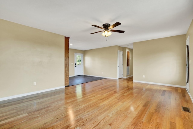 empty room with light wood finished floors, baseboards, visible vents, and ceiling fan