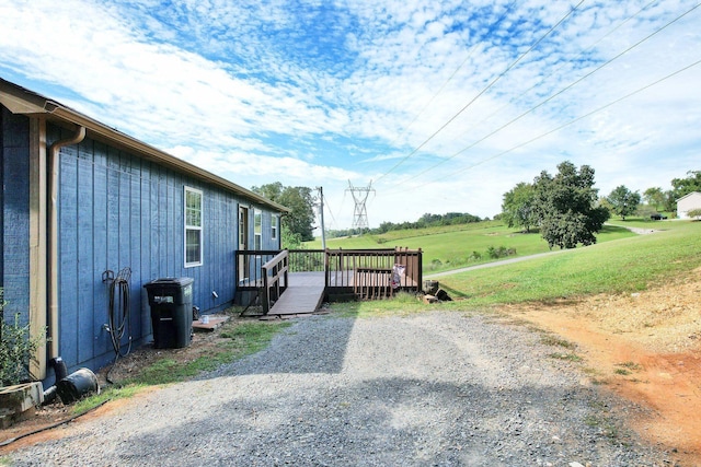 view of side of property featuring a lawn and a deck