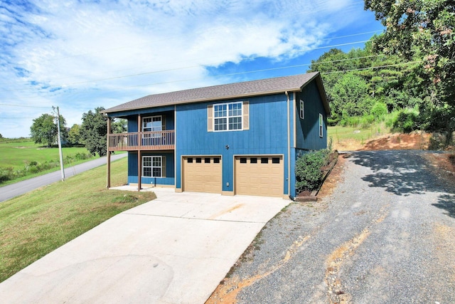 view of front of home with a garage, driveway, a front yard, and a balcony