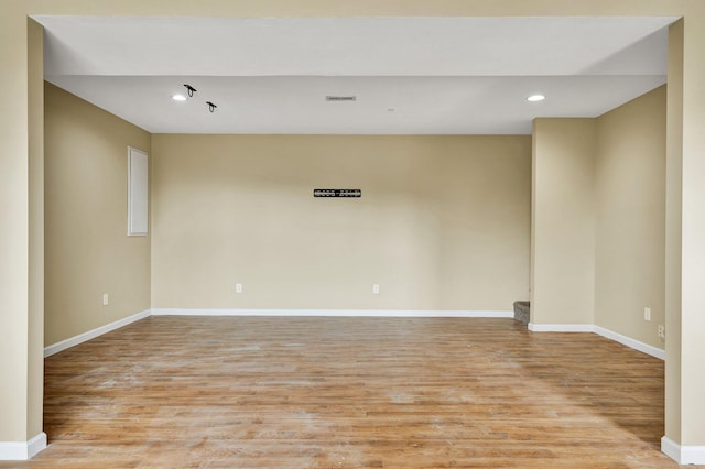 unfurnished room with light wood-type flooring, baseboards, and recessed lighting