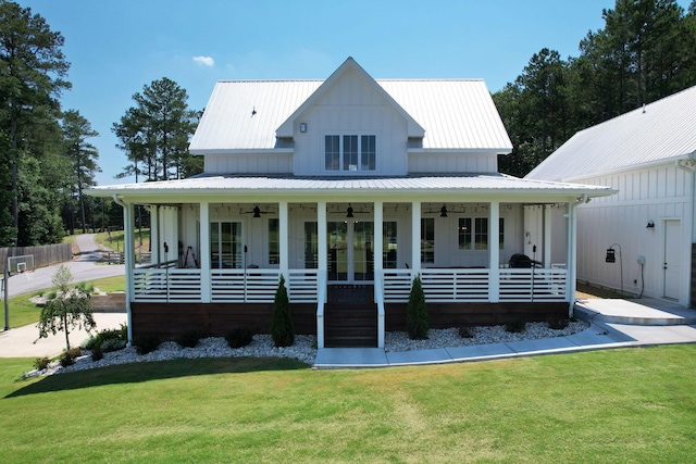 modern farmhouse featuring french doors, covered porch, ceiling fan, and a front lawn