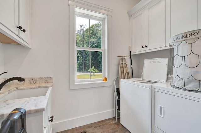 laundry room featuring independent washer and dryer, cabinets, sink, and a wealth of natural light