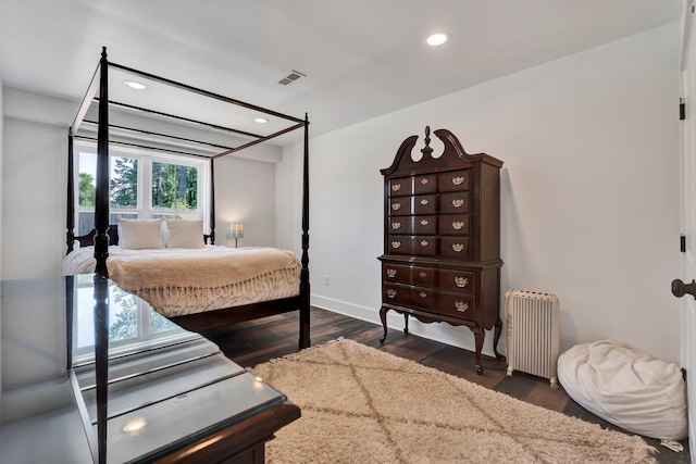 bedroom with radiator heating unit and dark hardwood / wood-style floors